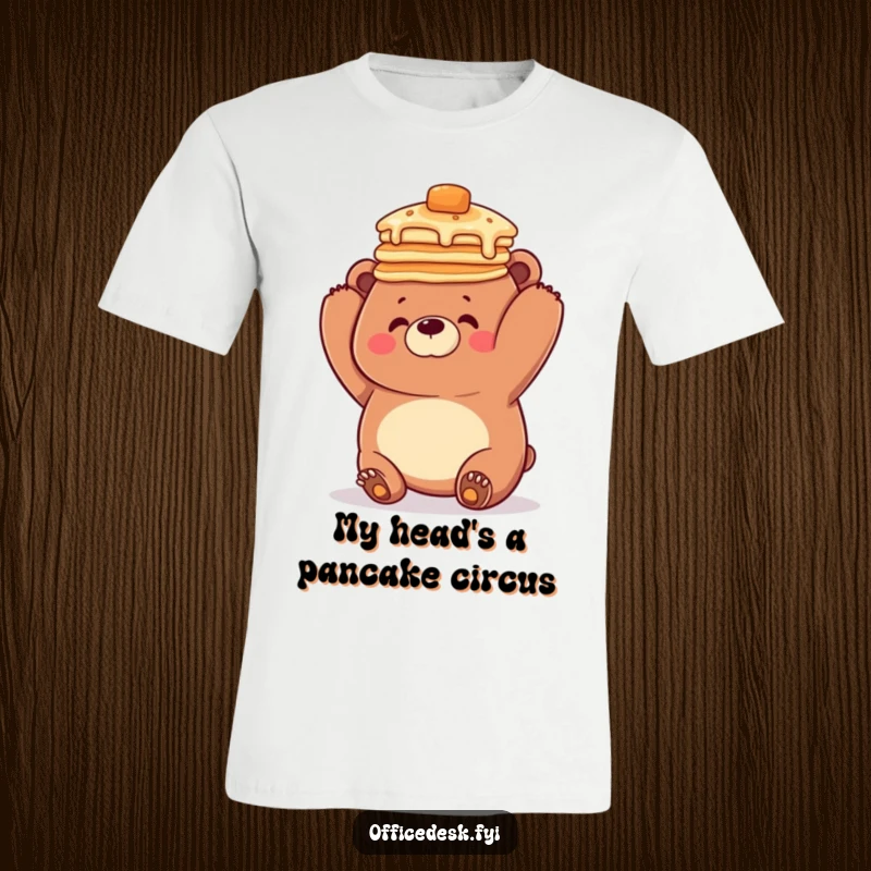 Funny t-shirt showing an adorable, clumsy bear hilariously trying to balance a massive stack of pancakes on its head, full of comedic energy.